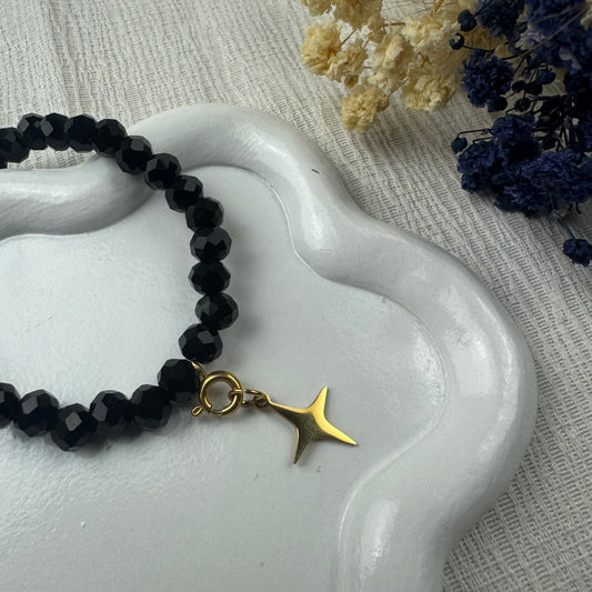bracelet en perles de verres noir et breloque étoile filante doré